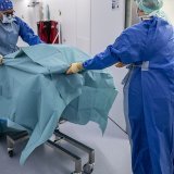 Thierry Berney (gauche), médecin-chef du service de transplantation des HUG, déplace un rein dans un autre bloc où attend un malade (archives 2022). KEYSTONE/MARTIAL TREZZINI